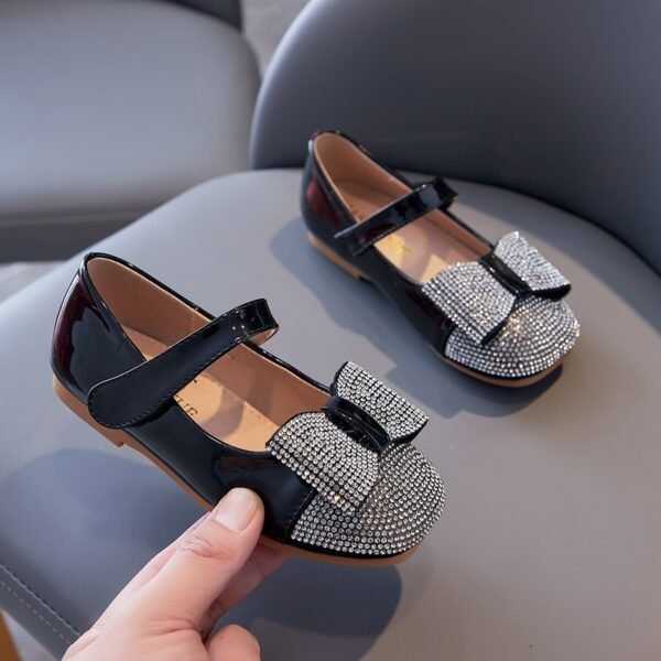 266e1098-f5a1-4d6c-a00c-02b02226a2eb.jpg حذاء مسطح من الجلد اللامع مزين بعقدة من أحجار الراين للفتيات الصغيرات