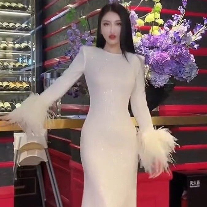 6b0a7e58-417a-4dd4-9169-925ec91ed8c8.jpg فستان أبيض بأكمام من الريش مع رقبة مستديرة وحواف من الخصر